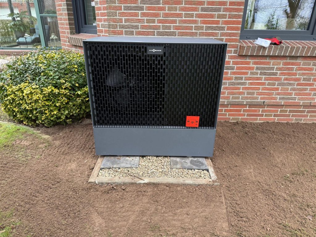 Kompakte Wärmepumpe harmonisch in den Garten integriert